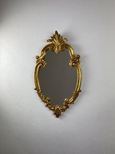 an ornate gold framed mirror on the wall