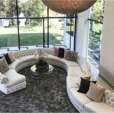 a living room filled with lots of white furniture and pillows on top of a rug