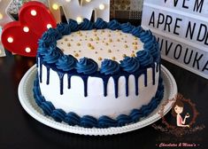 a cake with blue icing and gold sprinkles on it sitting on a table