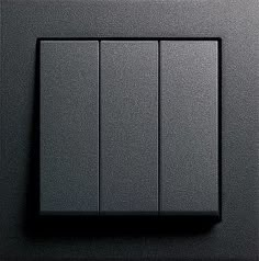 the light switch is black and has three lights on each side, which are dimmers