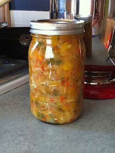 a glass jar filled with food sitting on top of a counter next to an oven