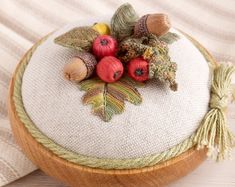 a close up of a wooden object with acorns and leaves on top of it