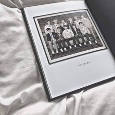 an open book with black and white photos on it's cover sitting on a bed