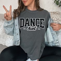 "Dance Aunt Tee, Proud and Loud Dance Aunt Gear, Dance Aunt Gift, Comp Dance Aunt Shirt, Trendy Dance Aunt Unisex Comfort Colors T-shirt How To Order - Please make sure you have looked at all sizes and color charts. - Select from the various T-Shirt sizes and colors from scroll down menus. - Fill in the personalization box (if provided) as exemplified. - Click \"Add to cart\" button. You can turn back and add more items of different size and color. Order Process - Our processing time is 5-10 days. - Shipping is first class, usually 1-5 business days (after processing time) depending on the location. - You can choose faster shipping options at checkout. (This does not affect the production time, production time remains the same, expedited shipping is only for delivery time that will be unde Dance Aunt Shirt Ideas, Comp Dance, Dance Shirts Ideas, Aunt Shirt, Fun Shirts, Aunt Shirts, Dance Shirts, Aunt Gifts, Sports Apparel