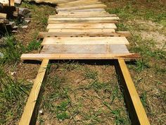 a wooden walkway made out of boards in the grass