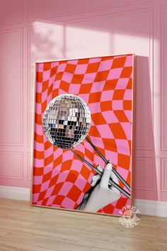 a pink and orange wall with a disco ball in the shape of a hand holding a pair of tongs