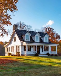 a large white house sitting on top of a lush green field