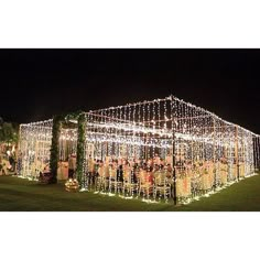 an outdoor wedding venue decorated with lights and greenery for the guests to sit on