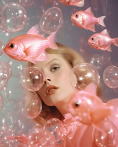 a woman is surrounded by bubbles and fish