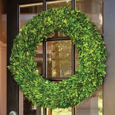 a green wreath is hanging on the front door to give it a festive touch