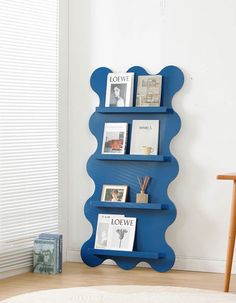 a blue shelf with pictures and books on it