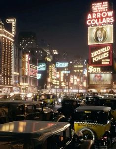 a busy city street filled with lots of traffic and tall buildings lit up at night