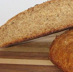 two loaves of bread sitting on top of a wooden cutting board