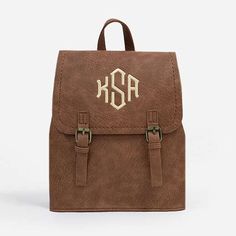 Keep up with all of your essentials with this convenient and cute Monogrammed Backpack Purse! Made of faux leather with front flap buckles, this backpack purse has two adjustable straps to fit comfortably. It can be worn both on the shoulder as well as a standard backpack. Check out our entire selection of monogrammed backpacks and monogrammed tote bags for more options! Want a full look? Check out our monogrammed clothing to complete the perfect ‘fit! Made of Faux Leather​ with Brus Preppy Backpack With Adjustable Strap, School Backpack With Adjustable Strap And Faux Leather, School Backpack With Adjustable Straps In Faux Leather, Brown Flap Backpack For School, School Leather Backpack With Flap And Adjustable Strap, Designer Monogram Canvas Backpack, Brown Monogram Canvas Backpack, Luxury Monogram Canvas Backpack, Monogram Canvas Backpack