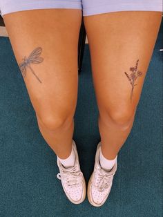 the legs and ankles of a woman with tattoos on her thighs, both showing small dragonflies