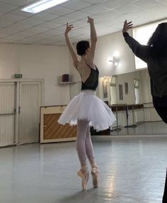 two ballerinas are in the middle of a dance class