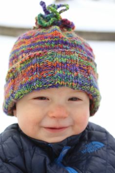 a small child wearing a colorful knitted hat