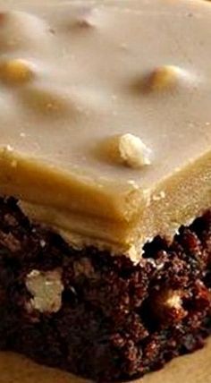 a piece of cake with frosting and nuts on top