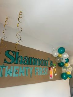 balloons and streamers are hanging from the ceiling in front of a sign that says shanmon's twenty first