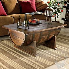 a wooden table topped with wine glasses and fruit on top of a carpeted floor