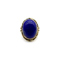 This is part of Chairish’s Fine Jewelry assortment.  A vivid blue lapis cabochon is bezel set into a halo of 22k gold nuggets. The stone is a deep, well-saturated cobalt blue, while the gold nuggets bring richness and texture to the surface of the ring. The effect is stunning, and the two elements compliment each other beautifully. The 14k gold band splits into three, adding a hint of drama and elegantly framing the lapis centrepiece. A bold cocktail ring, true blue!  This type of nugget work ar Gold Domed Gemstone Cabochons, Domed Gold Gemstone Cabochons, Yellow Gold Lapis Lazuli Cabochon Jewelry, Yellow Gold Lapis Lazuli Gemstone Rings, Yellow Gold Rings With Lapis Lazuli Gemstone, Gold Oval Lapis Lazuli Jewelry, Gold Lapis Lazuli Cabochon Jewelry, Oval Gold Lapis Lazuli Jewelry, Gold Lapis Lazuli Jewelry With Cabochon