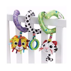 three stuffed animals hanging from the side of a white rail next to a green ring