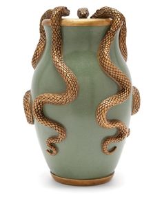 a green vase with two snakes on it