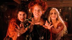 three women dressed as witches posing for the camera with their hands in front of them