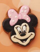 a minnie mouse cookie with a pink bow on it's head is shown in front of an orange background