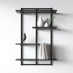 a shelf with books and vases on it against a white wall in an empty room