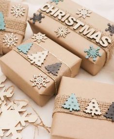 three presents wrapped in brown paper with snowflakes on them and the words christmas