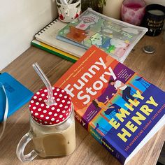 there is a book and a drink on the table next to it, along with other children's books