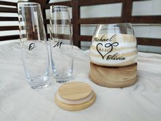 two wine glasses sitting on top of a table next to a coaster and bottle opener