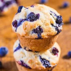 three blueberry muffins stacked on top of each other with fresh blueberries in the background