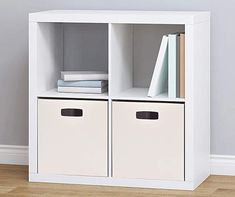 a white bookcase with two bins next to it