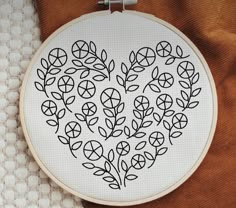 a cross stitch heart with leaves on it