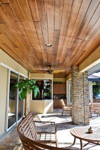 an outdoor covered patio with wooden furniture