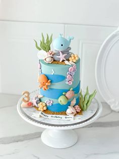 there is a blue and white cake with sea animals on the top, along with other decorations