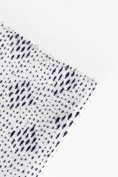 a piece of white fabric with black dots on it