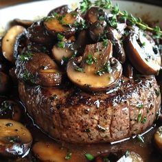 a close up of a plate of food with meat and mushrooms on it's side