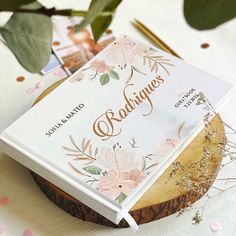 an open book sitting on top of a wooden slice next to a potted plant