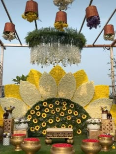 an outdoor display with flowers and vases on the grass