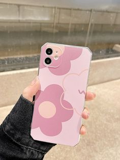 a person holding up a pink phone case with flowers on the front and back cover