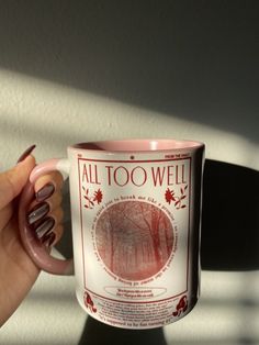 a woman's hand holding a coffee mug with the words all too well on it