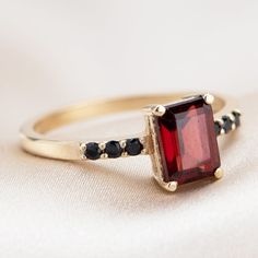 Beautifully stunning, this Deco-inspired ring features Garnet and black diamonds and is sure to turn heads. Black Ruby Rings As Gift, Black Ruby Rings For Gift, Black Ruby Rings For Gifts, Black Ruby Ring Jewelry, Elegant Yellow Gold Ring With Black Spinel, Elegant Yellow Gold Rings With Black Spinel, Formal Yellow Gold Rings With Black Spinel, Formal Black Rings With Ruby, Classic Black Spinel Promise Ring