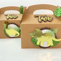 two cardboard boxes with dinosaur cut outs on them