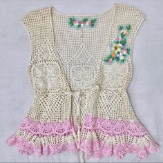 A Beautiful Vintage Buttercream Crocheted Top With A Tie Front And Peplum Waist. Decorated With Embroidered Floral And Bird Accents On The Chest And Powder Pink Along The Bottom. Would Be Super Cute With Jeans, Denim Shorts Or A Skirt. Perfect Condition, No Stains, No Pulls, Never Worn. Waist Is About 25” Across But The Fabric Has Some Give. It Is Adjustable As The Tie Is Through The Weaving Of The Fabric And Can Be Moved As Wide Or Tight As Possible. Pink V-neck Crochet Top For Spring, Spring Sleeveless Crochet Top With Floral Embroidery, Sleeveless Crochet Top With Floral Embroidery For Spring, Sleeveless Crochet Top With Floral Embroidery For Beach, Floral Embroidery Sleeveless Crochet Top For Beach, Floral Embroidered Sleeveless Crochet Top For Beach, Fitted Crochet Top With Crochet Trim For Spring, Fitted Crochet Trim Top For Spring, Spring Pink Lace Patchwork Top