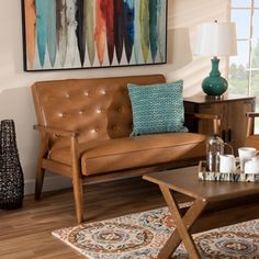 a living room filled with furniture and a painting on the wall above it's coffee table