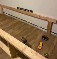 some tools are laying on the floor in front of a wooden bench that is being built