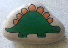 a painted rock with an image of a dinosaur on it